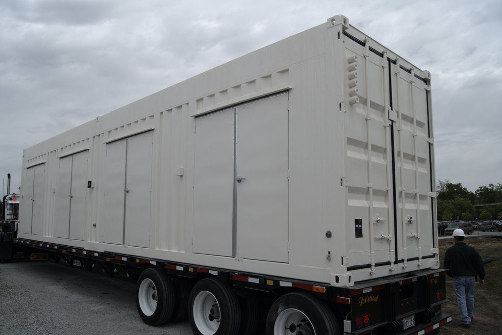 Large enclosure loaded on a flatbed trailer